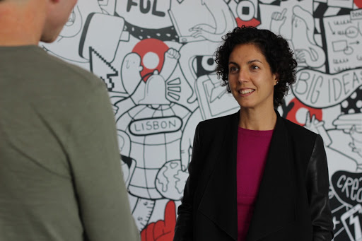 Andreia Mesquita, UX/UI Team Lead, looking at a person in front of her in the OutSystems office.